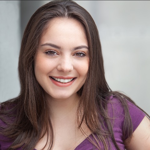 Melissa Aliotta headshot: smiling in purple shirt with white-gray background