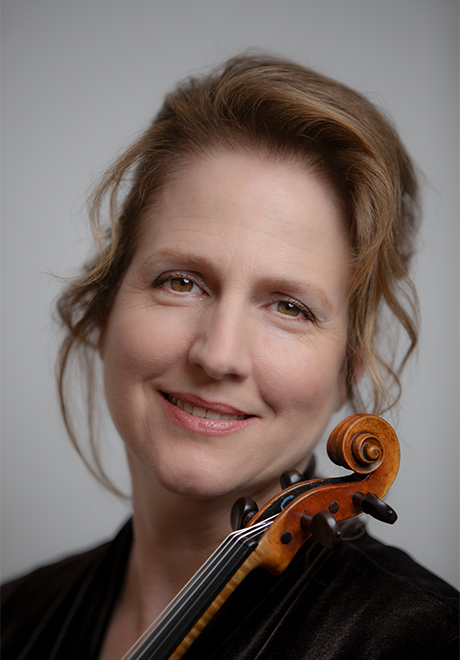 Katie Lansdale headshot: smiling and posing with violin and grey background.