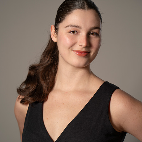 Solana McGonagle headshot; smiling and wearing a black v-neck top
