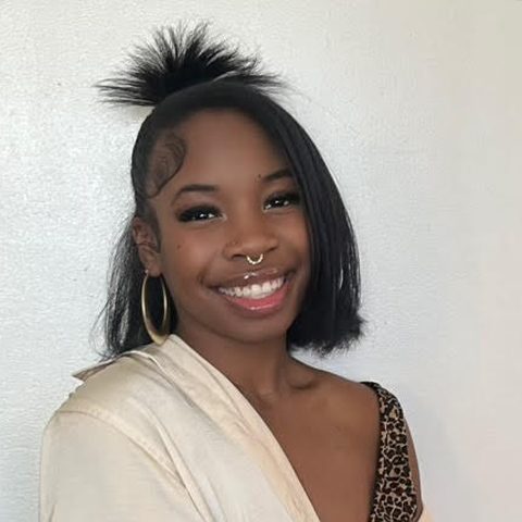 Gianna Jones headshot: smiling in white shirt in front off off-white background