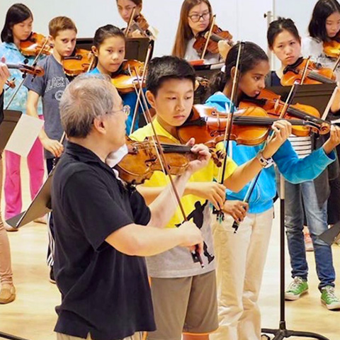 A teacher and group of students in Boston String Academy playing together