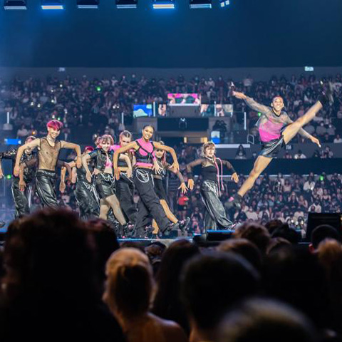 Commercial dance students in pink and black outfits dancing on stage at KCON