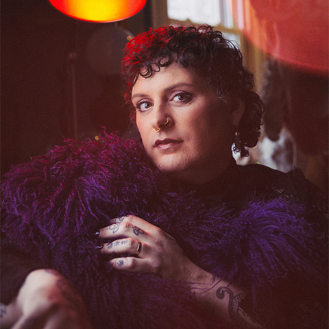 Jessye poses for the camera in front of orange lights 