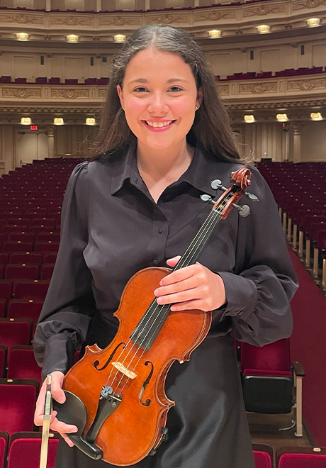 Acadia Kunkel headshot: smiling in all black clothes holding a violin