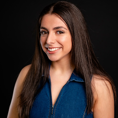 Amanda Rosenberg headshot: wearing a denim top in front of a black background.