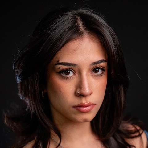 Electra Torres-Smith headshot: posing in front of a black background