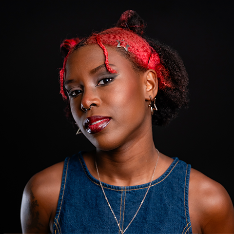 Journee Brownridge headshotLposing in a denim top and red bandana in front of a black background.