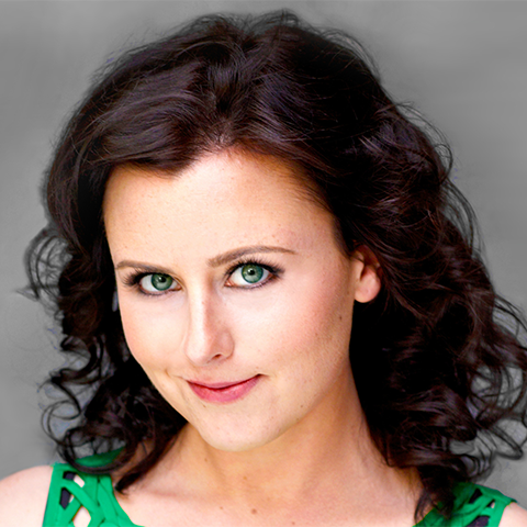 Bridgette Hayes headshot: smiling in front of a gray wall and wearing a green tank top.