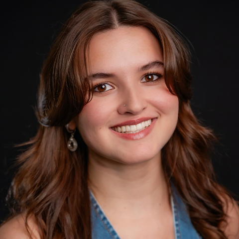Callie Wood headshot: wearing a denim shirt in front of a black background