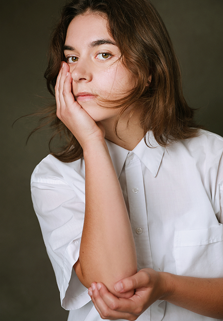  Grayson Gizdic headshot: posing with had on cheek in a white shirt