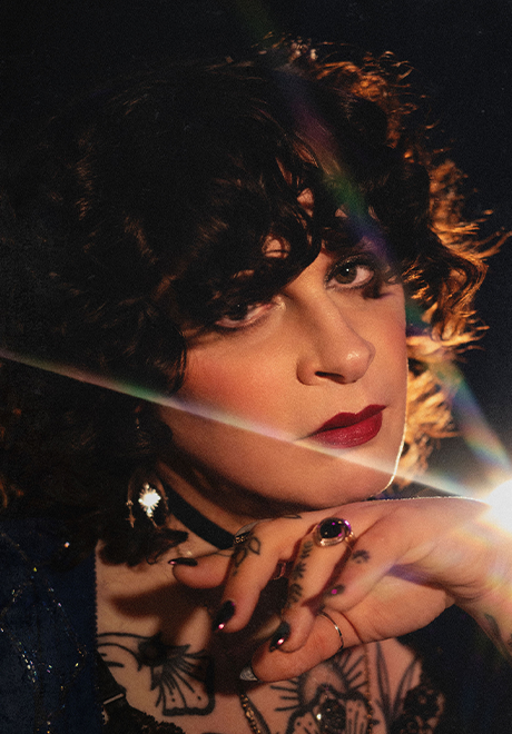 Jessye DeSilva headshot: close up shot of Jessye resting her hand under her chin