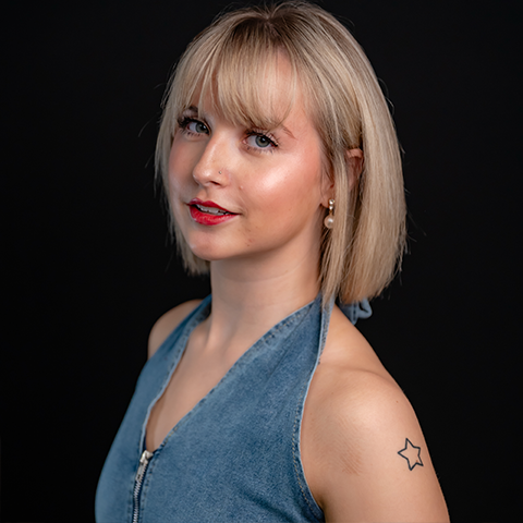 Kynlee McBride headshot: wearing a denim top in front of a black background.
