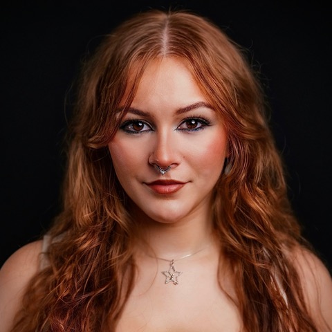 Star Kensing headshot: smiling in front of a black background