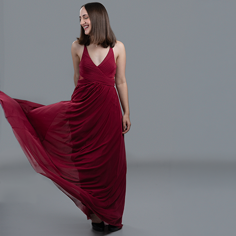 Liana Greger photo: wearing long red dress in front of gray background