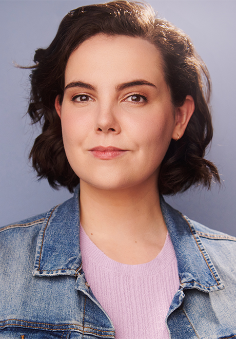 Allison Beauregard headshot: grinning in denim jacket and pink top