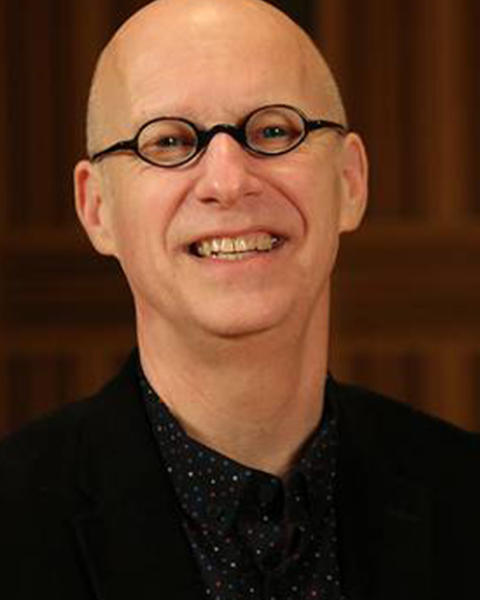 Headshot of William Cutter with a brown background
