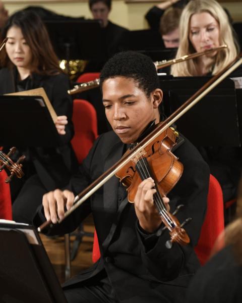 Violinist performs with an orchestra