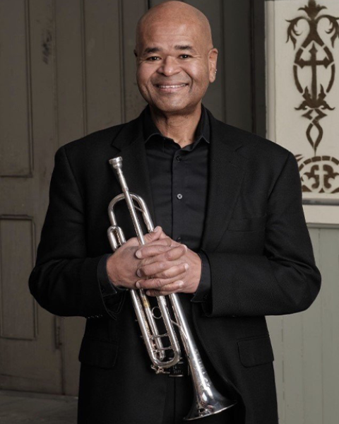 Richard Kelley in black suit posing with trumpet