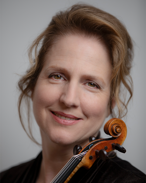 Katie Lansdale headshot: smiling and posing with violin and grey background.