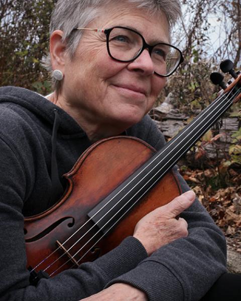 Judith Eissenberg headshot - holding violin and grinning