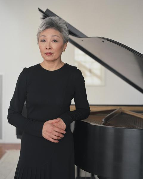 Jung-Ja Kim posing next to a grand piano