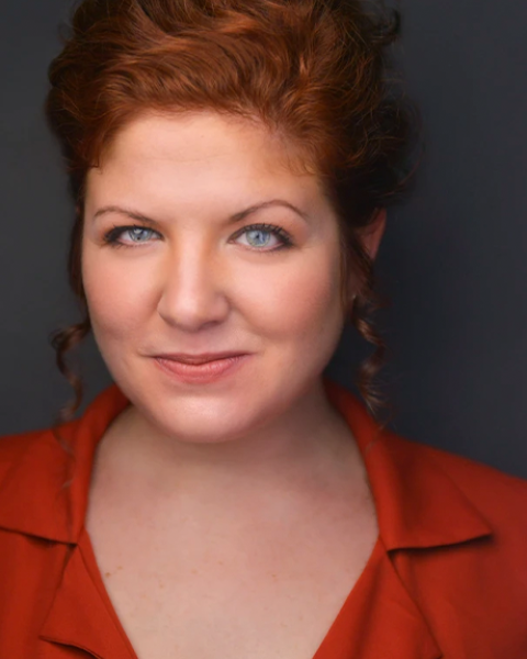 Meagan Lewis-Michelson headshot, wearing red shirt and grinning
