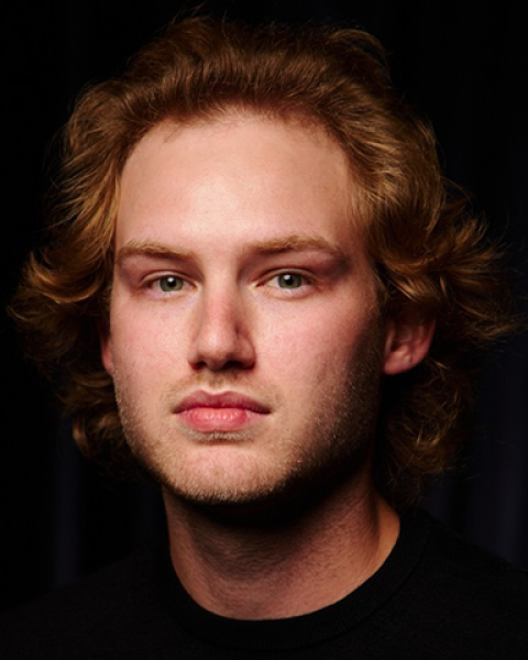 Matthew Carey headshot with a black background