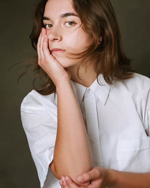  Grayson Gizdic headshot: posing with had on cheek in a white shirt