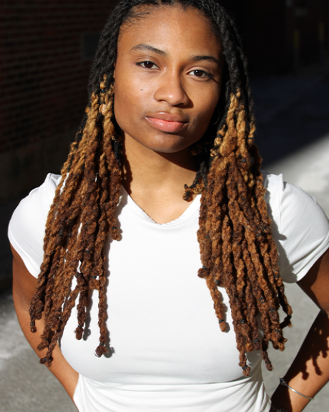 Heaven Williams headshot: wearing a white shirt in front of a black background