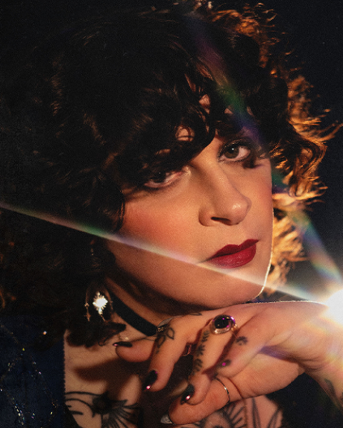 Jessye DeSilva headshot: close up shot of Jessye resting her hand under her chin