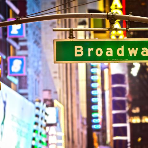A stoplight and street sign that says Broadway