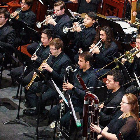 Wind Ensemble performing (trumpets, clarinets, bassoons, trombones, and horns pictured.)