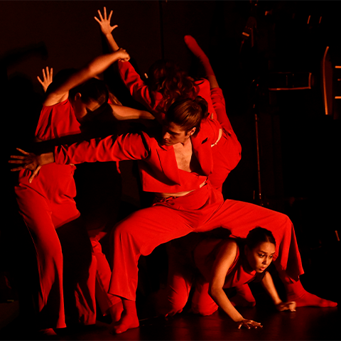 Four students in red outfits dancing