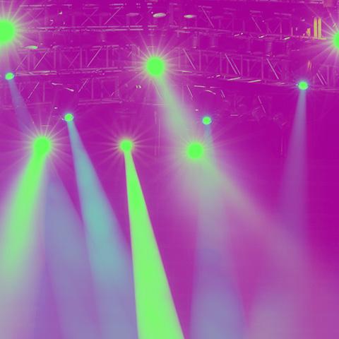 Spotlights (yellow colored) shinning in a theater (pink-purple hue)