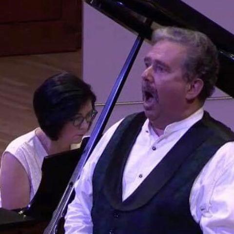 Jean Anderson playing piano as David Small sings 