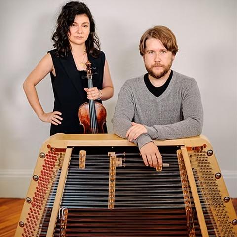 music duo stands in front of their instruments 