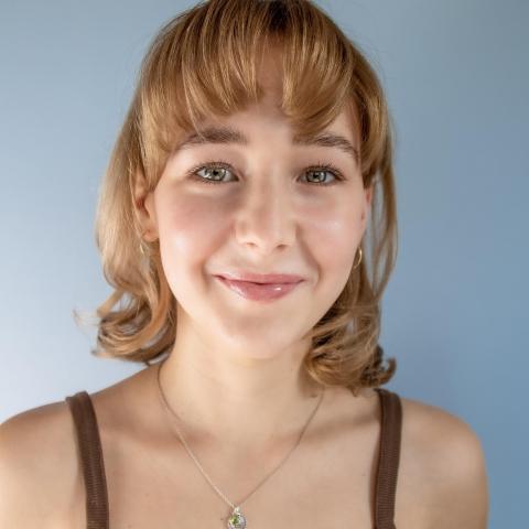 Virginia Vogel headshot: smiling in front of blue background