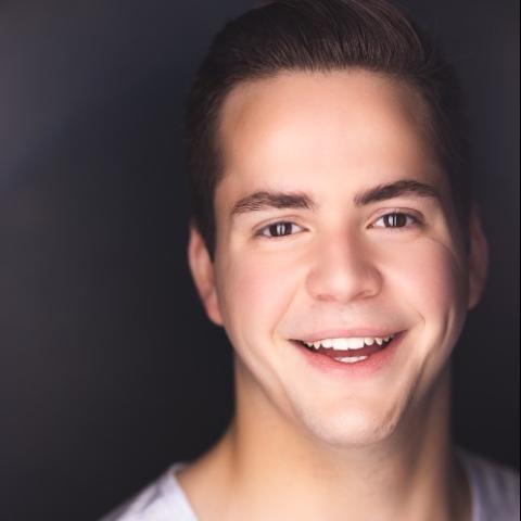 Connor Buonaccorsi headshot: smiling in front of dark gray background