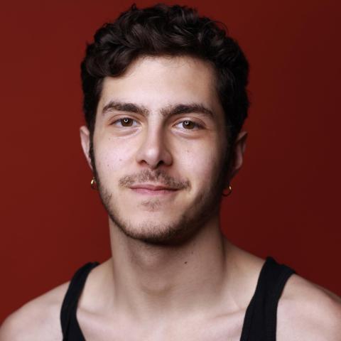 Ian Viciedo headshot: grinning in black tank top in front of red background