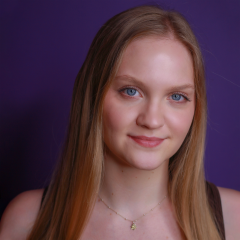 Sylvia Taylor headshot: smiling in front of purple background