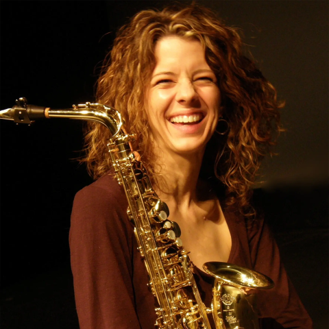 Carrie Koffman smiling and holding her saxophone