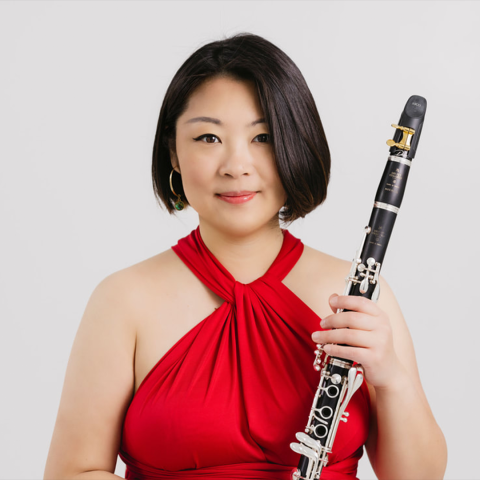 Tzuying Huang headshot; wearing a red dress and holding clarinet