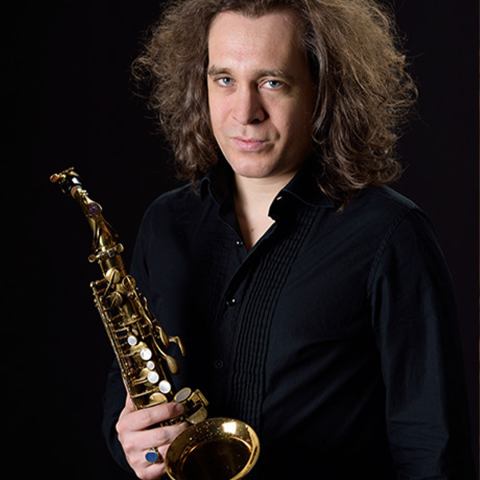 Philipp Stäudlin headshot holding saxophone