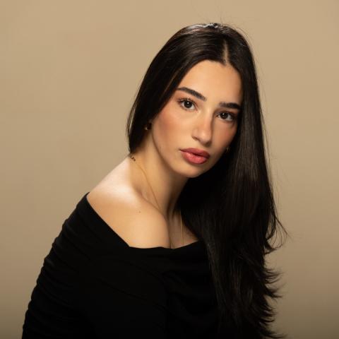 Ellie Balzano headshot in black off-the-shoulder shirt