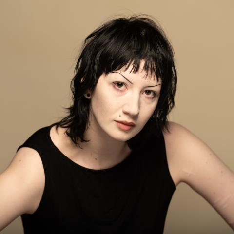 Emma Hourigan headshot: posing in a black tank top