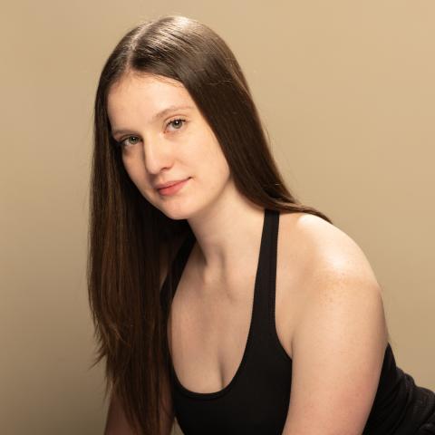 Emma Jane Zaher headshot: grinning in a black tank top