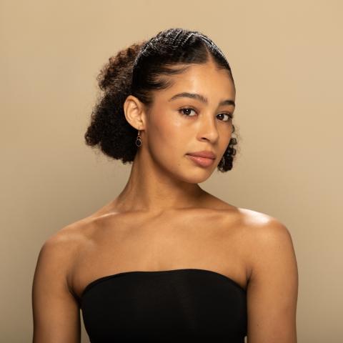 Esmé Stone headshot, posing in a black tube top