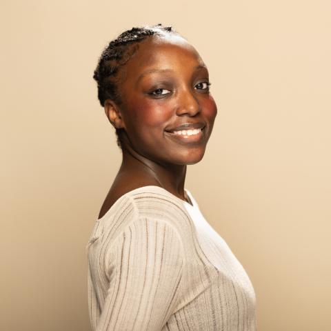 Kayenne Charles-Pierre headshot, smiling in a white shirt