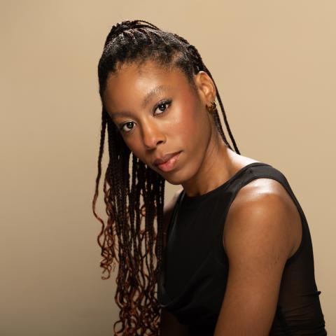 Kay Williams headshot: posing in a black tank top