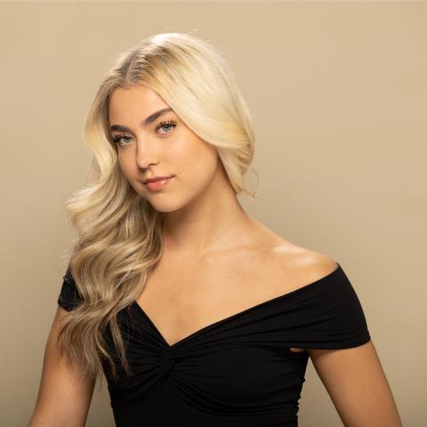 Mackenzie Campbell headshot: grinning in black off-the-shoulder shirt